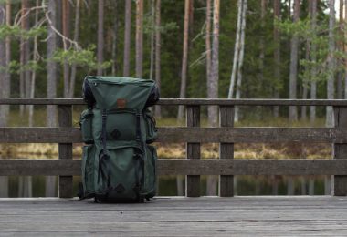 a hiking backpack on a deck outdoors with trees in the background